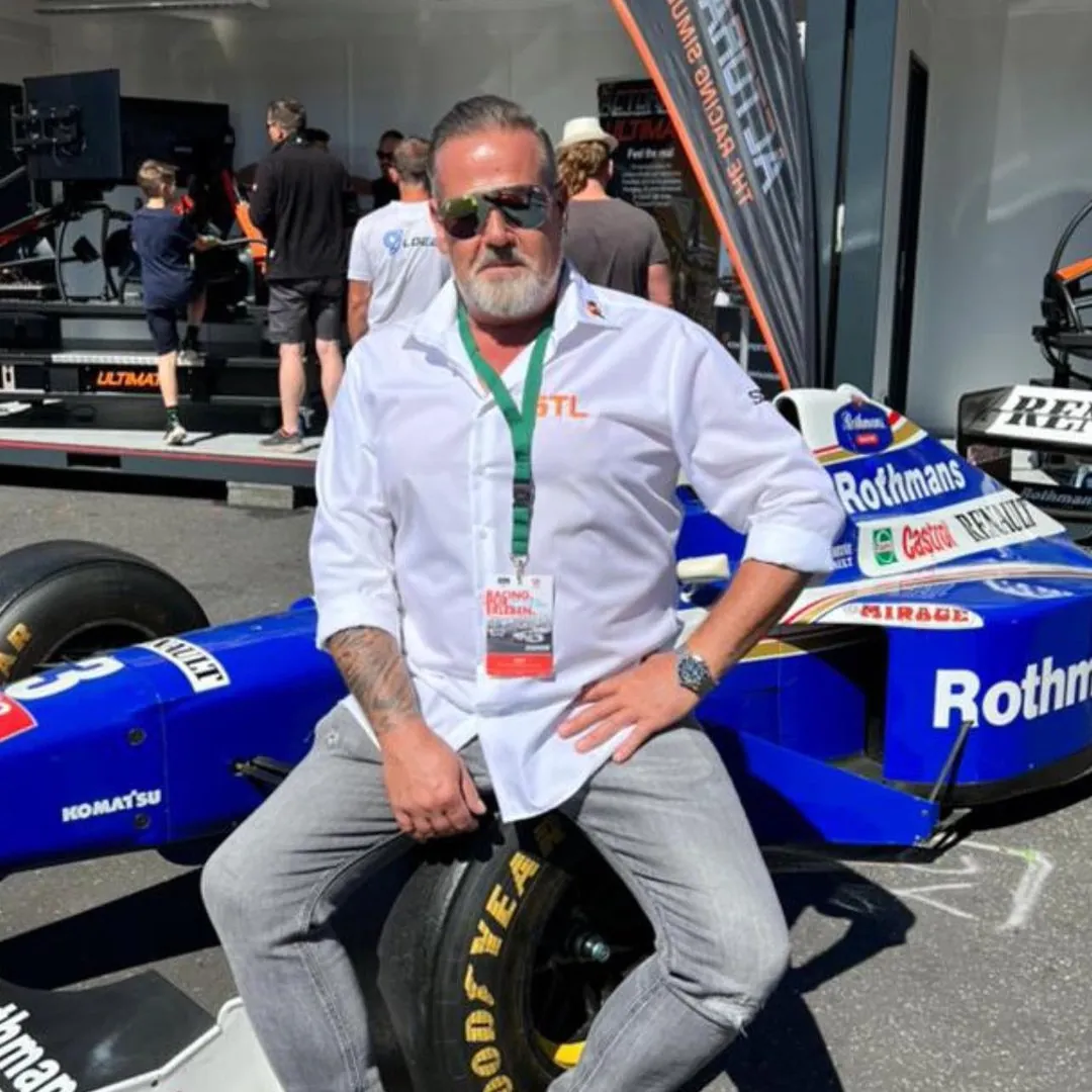 Dirk Klesper sitzt auf einem Formel-1-Rennwagen