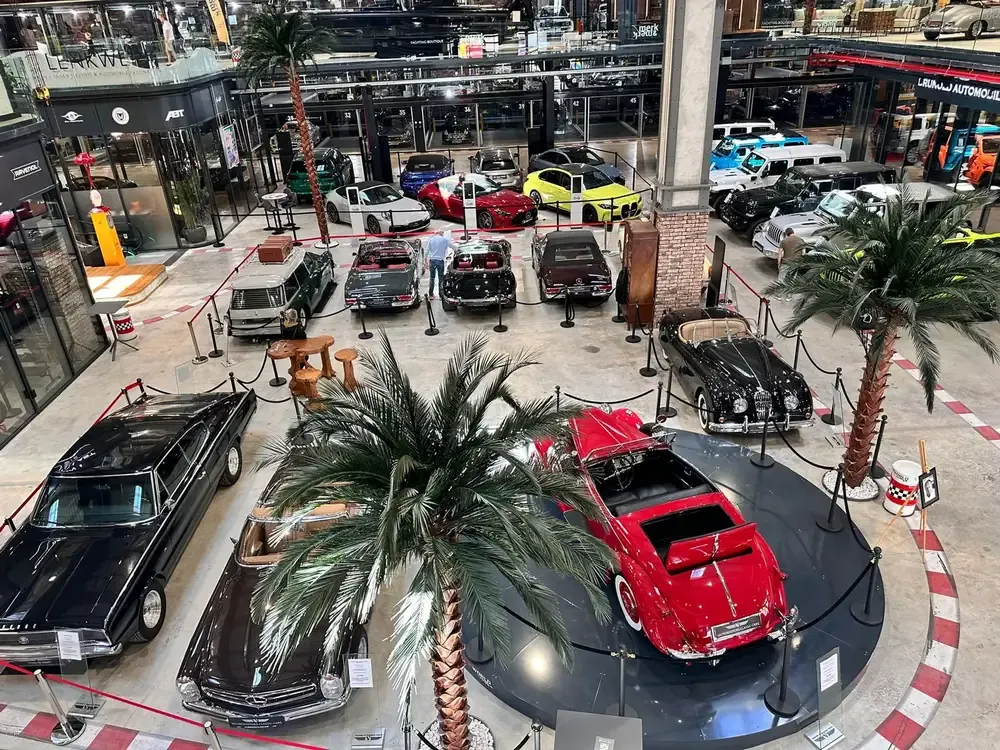 Ausstellungshalle der Motorworld Mallorca mit Oldtimern und Palmen